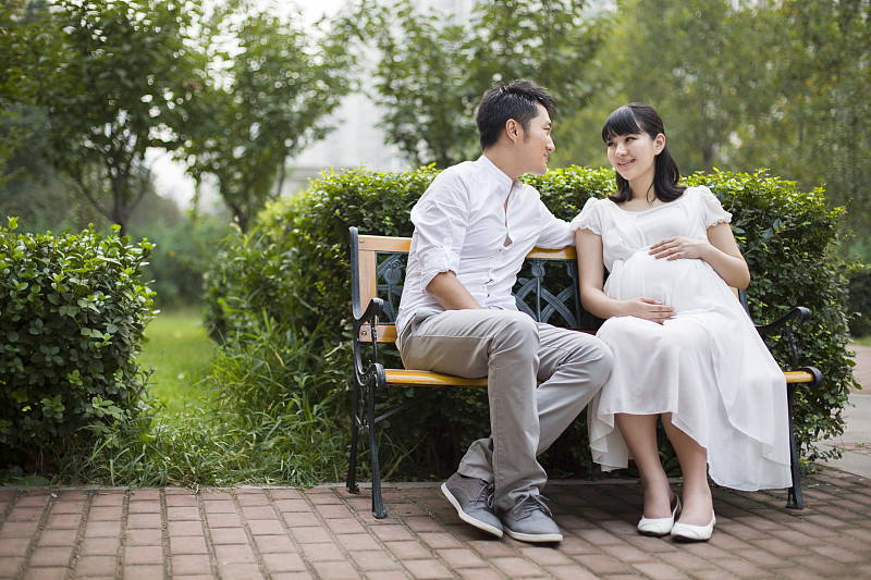 孕妇和丈夫坐在长椅上图片下载