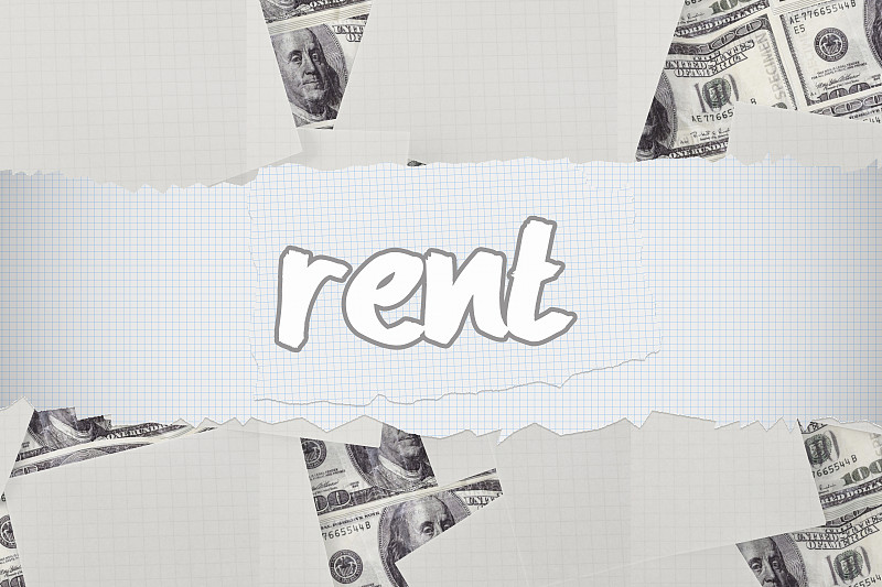 “租金”这个词映衬着散落在钞票上的白纸图片下载