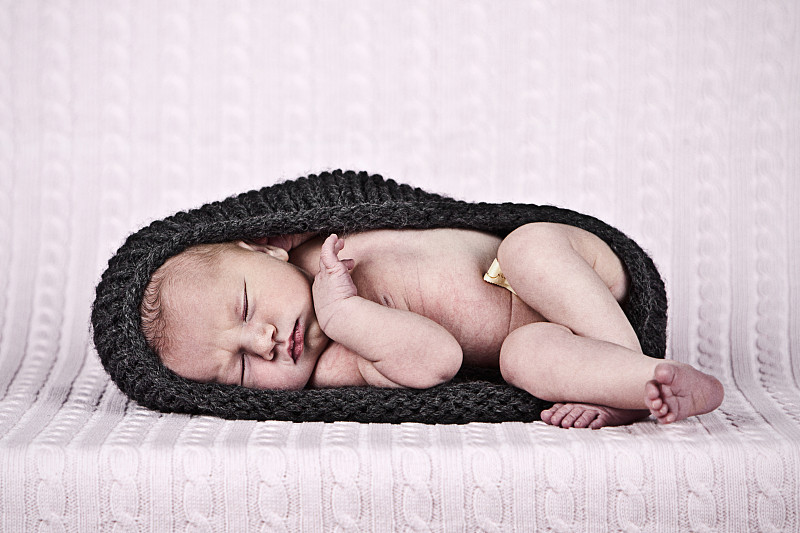 Newborn baby girl (0-1 month) in woolen pod图片素材