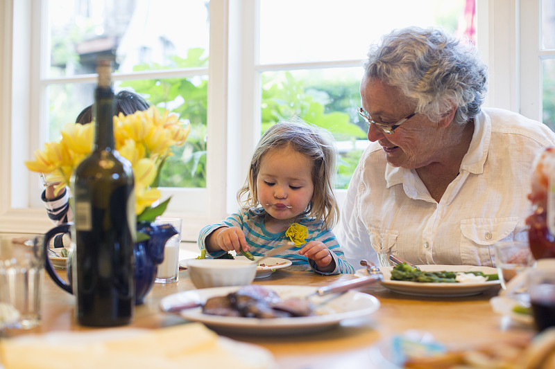 美国加州，小女孩(2-3岁)和奶奶一起吃晚饭图片下载