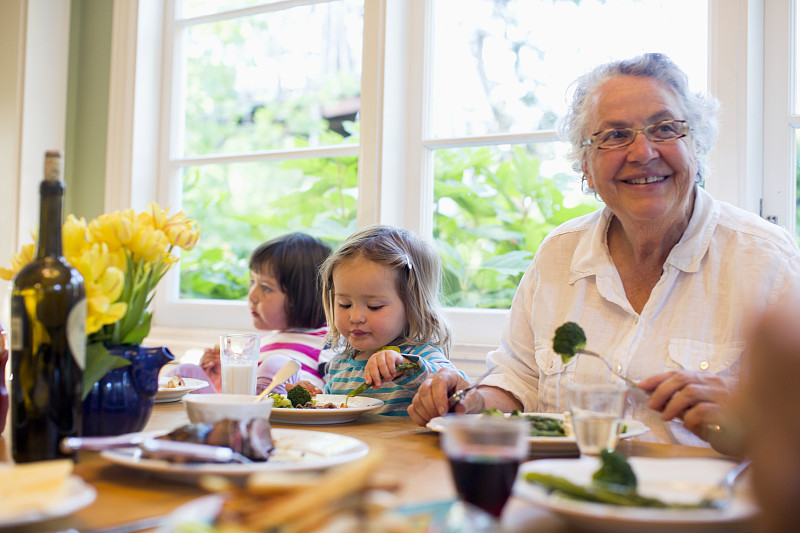 两个孙女(2- 3,4 -5)和奶奶一起吃晚餐，美国加州图片下载