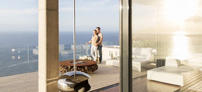 一对夫妇在现代化的阳台上俯瞰大海图片下载