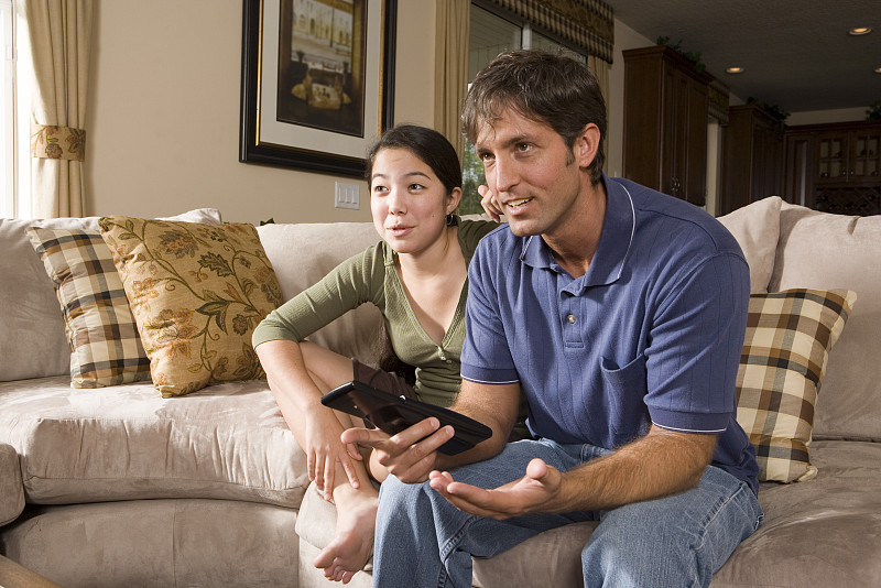 父亲和女儿在沙发上看电视图片下载