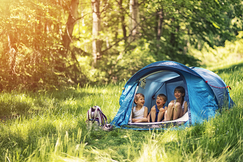 徒步旅行者的孩子们坐在森林里的帐篷里图片下载