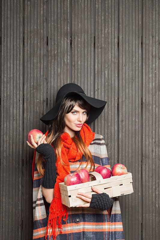 秋天的肖像时尚的年轻女子拿着篮子的苹果图片素材