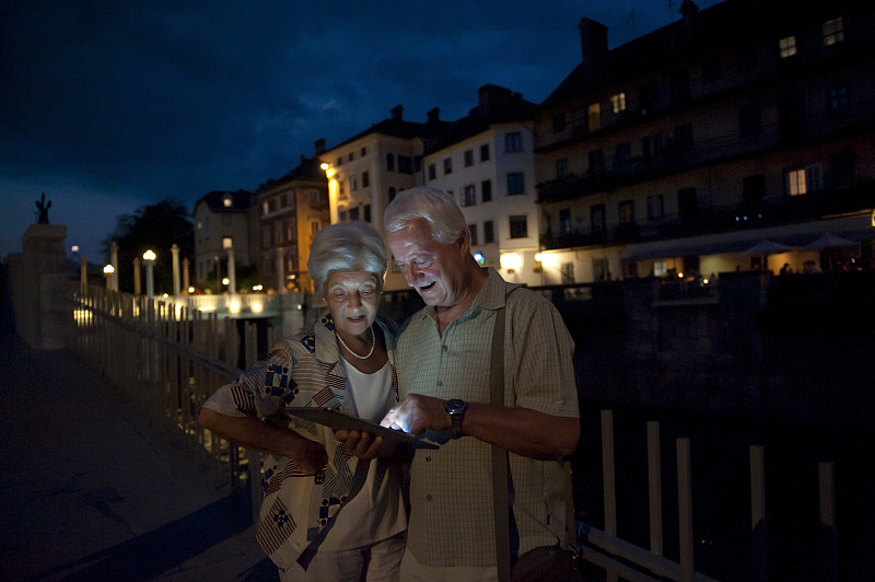 一对老年夫妇晚上在用平板电脑图片下载