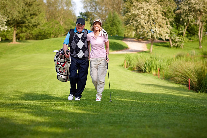 一对快乐的老夫妇在球场上打高尔夫图片下载
