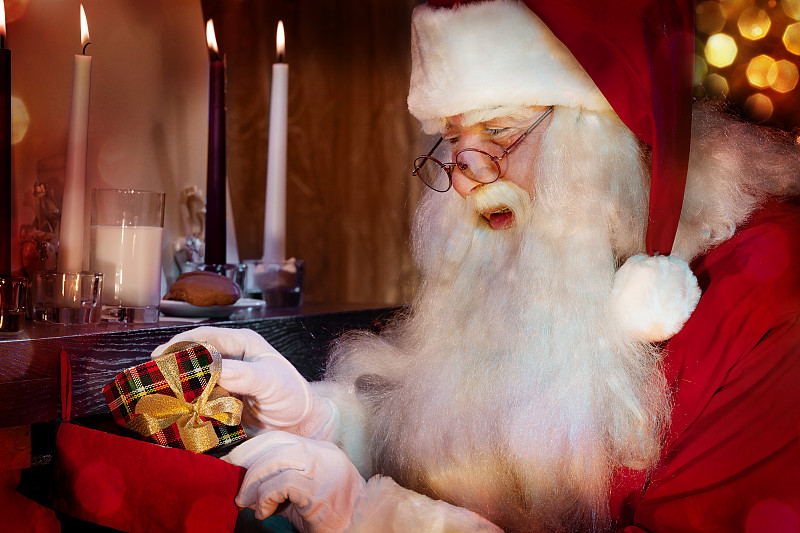 经典的圣诞老人把礼物放在圣诞袜里。图片下载