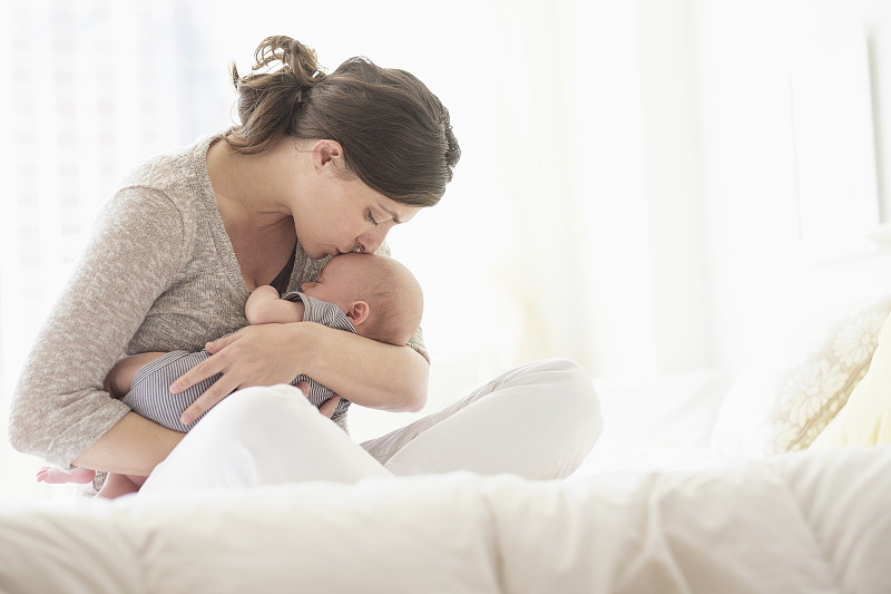 美国，新泽西州，泽西城，母亲在床上亲吻婴儿(2-5个月)图片下载