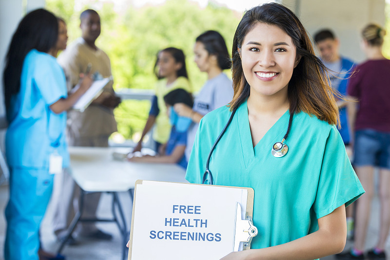 微笑的护士举着“免费健康检查”的牌子图片下载