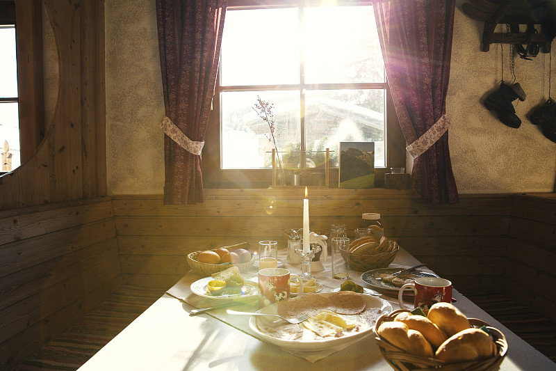 Sunlit breakfast table in log cabin图片素材