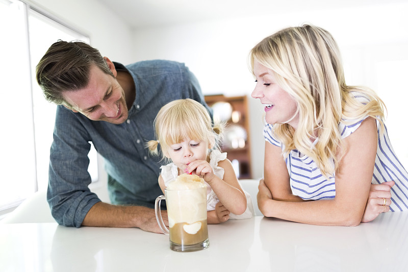 女孩(2-3)在家和父母一起喝奶昔图片下载