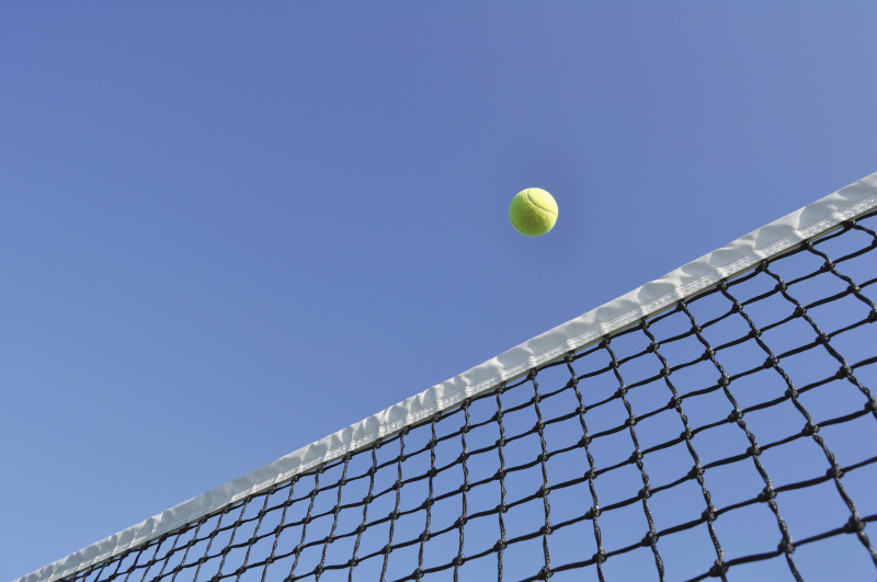 在半空中越过网的网球图片下载