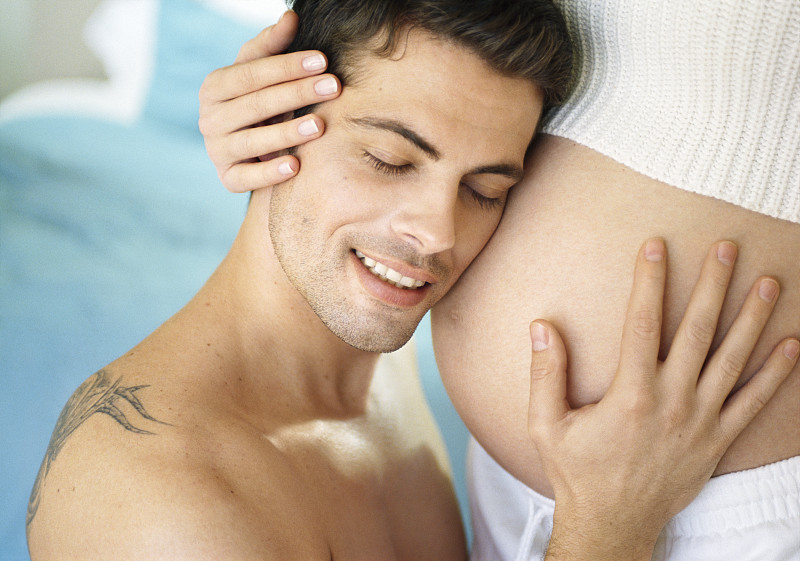 男人抚摩着怀孕的老婆肚子，听着图片下载