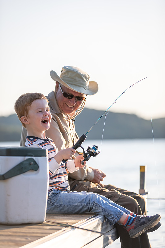 爷爷和孙子在夏天的日落钓鱼图片下载