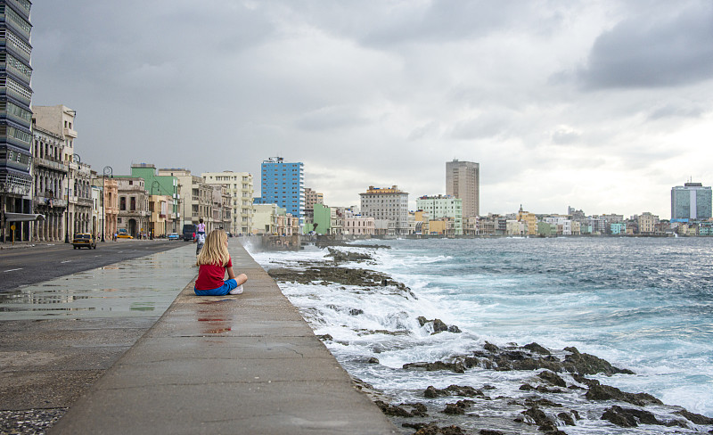 Malecón大街上的金发男孩在海堤上休息，哈瓦那老城，古巴图片素材