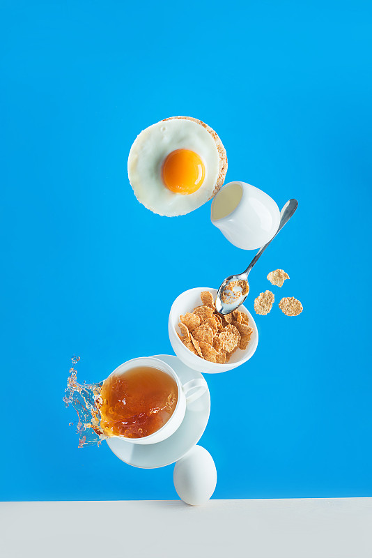 健康的早餐有麦片和鸡蛋吐司，色彩鲜明的蓝色背景上均衡的食物图片素材