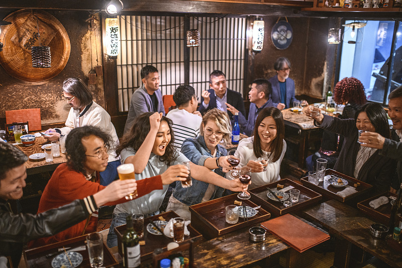一群朋友在东京居酒屋寿司酒吧祝酒图片素材