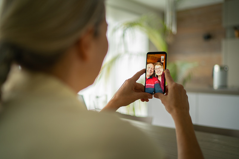 微笑的成年父母与女儿通过手机视频通话图片下载