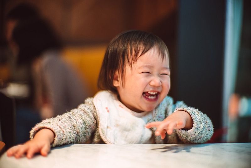 可爱的婴儿在餐厅快乐的微笑图片下载