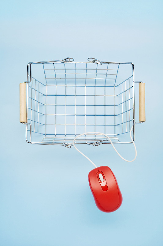 高角度的空购物篮和红色鼠标在蓝色背景，网上购物图片素材