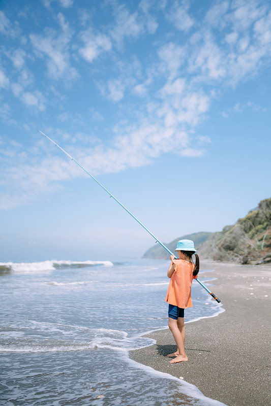 小女孩在东京湾的海滩上钓鱼图片下载