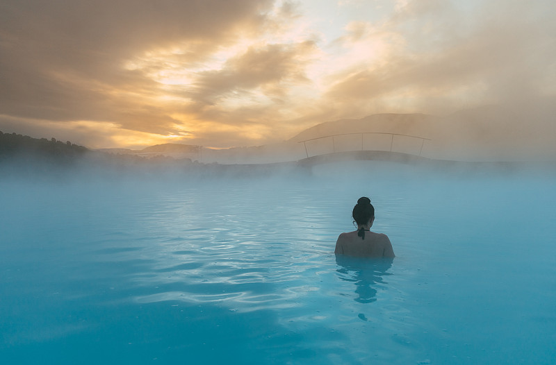 一个女人的后视图站在蓝礁湖，冰岛图片素材