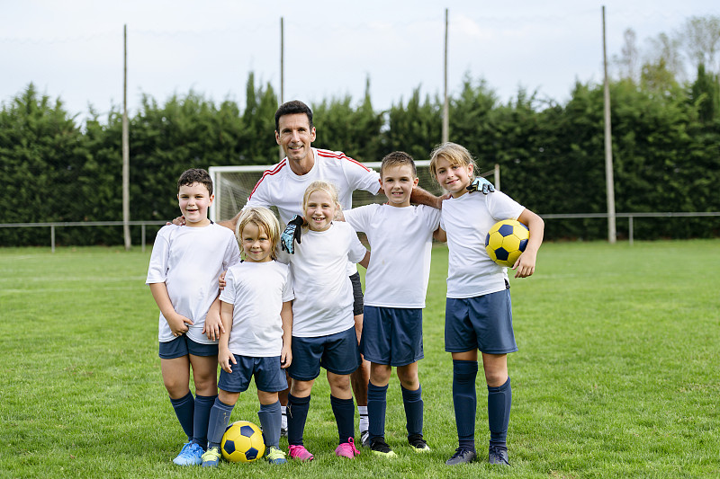 年轻的男孩和女孩足球运动员和教练的集体肖像图片素材