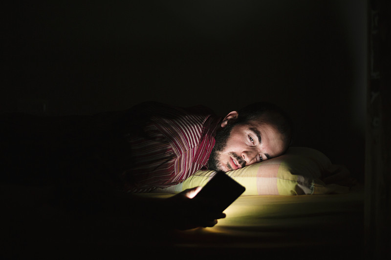 男人晚上躺在床上玩手机图片下载