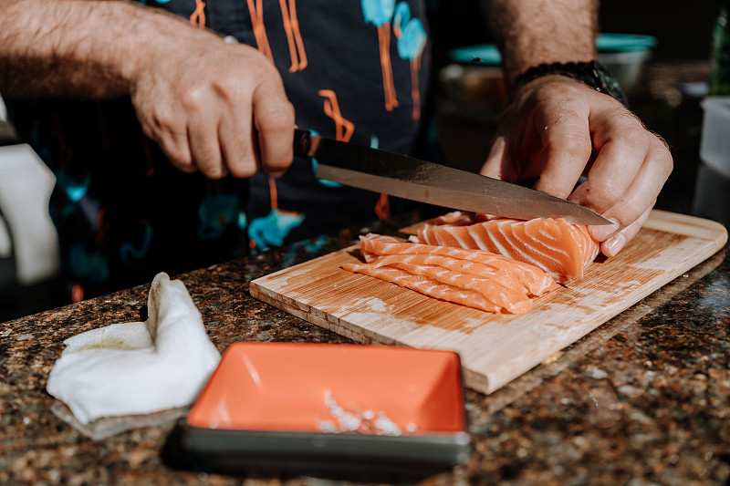 Man slicing salmon图片素材