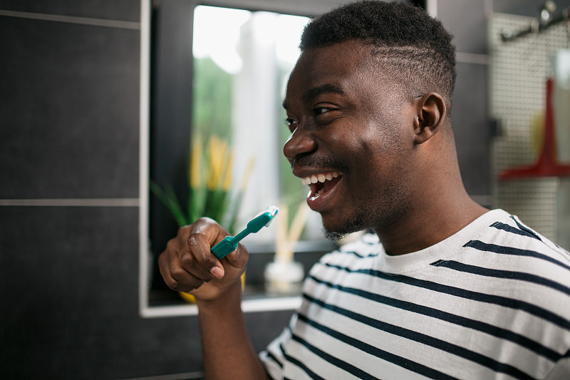 一个年轻的非裔美国人正在家里刷牙图片下载