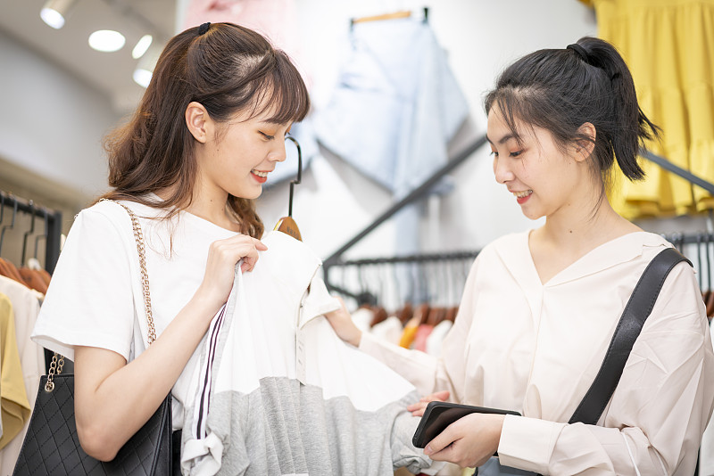 两个年轻妇女在一家购物中心买衣服图片下载