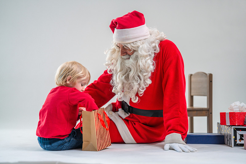 圣诞老人给白人金发可爱的男孩圣诞礼物图片下载