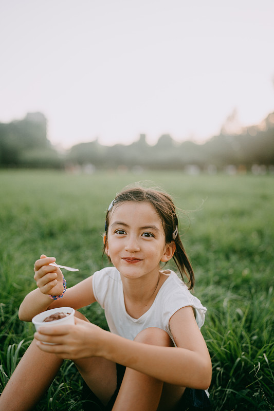 在东京的一个公园里，一个快乐的小女孩正在享用冰淇淋图片下载