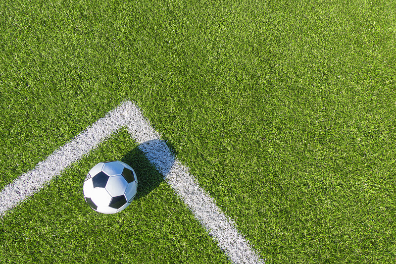 足球运动背景。足球在绿色的人工草地上，草坪上有白色的线。俯视图图片下载