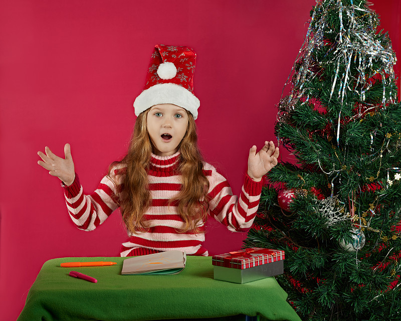 圣诞节，假日和童年概念-微笑的女孩制作愿望清单或写信给圣诞老人在家图片下载