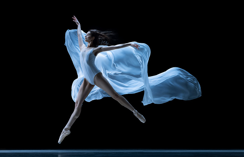 优雅的经典芭蕾舞演员跳舞与失重织物孤立在黑色霓虹灯工作室背景。戏剧，艺术，美，优雅，动作和运动的概念。图片下载