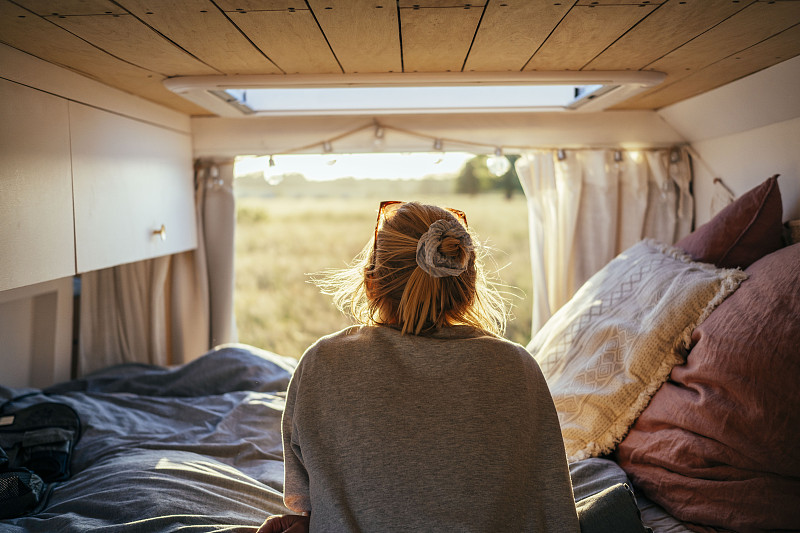 一个站在露营车后面看风景的女人图片下载
