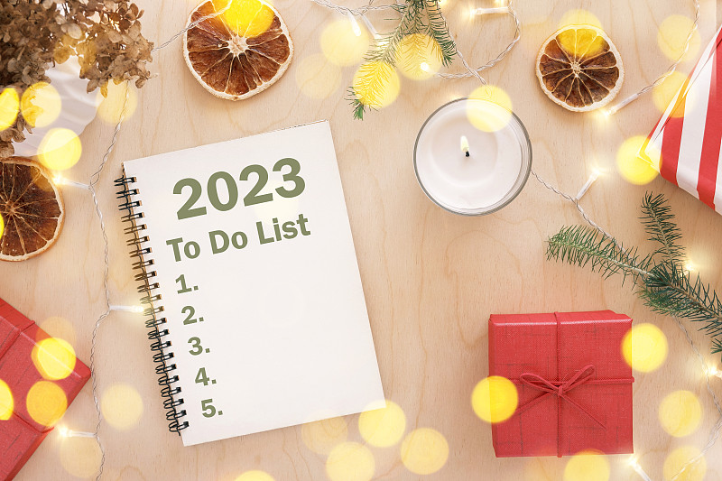 新年目标。2023待办事项清单写作。写在空笔记本木桌子与圣诞装饰。前视图。制定目标清单和决心。新生活，开始，开始的概念。经营理念图片下载