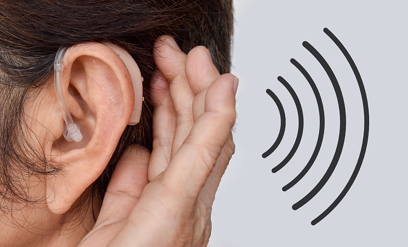 电子助听器在亚洲女性耳朵完全失聪。图片下载