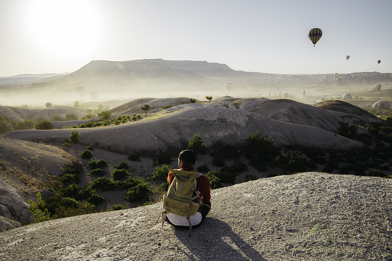 年轻男子享受日出与热气球的观点在戈尔梅图片下载
