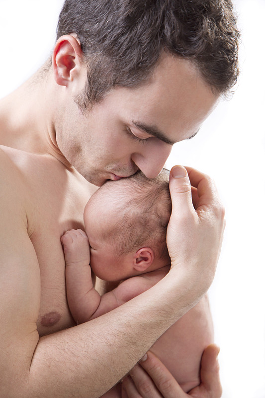 Father kissing son against white background, close up图片素材