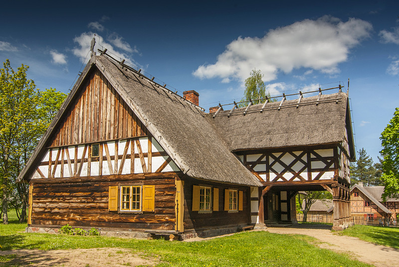 来自波兰Olsztynek的Masuria地区的带有拱廊扩建、半木墙和茅草屋顶的小屋。图片下载