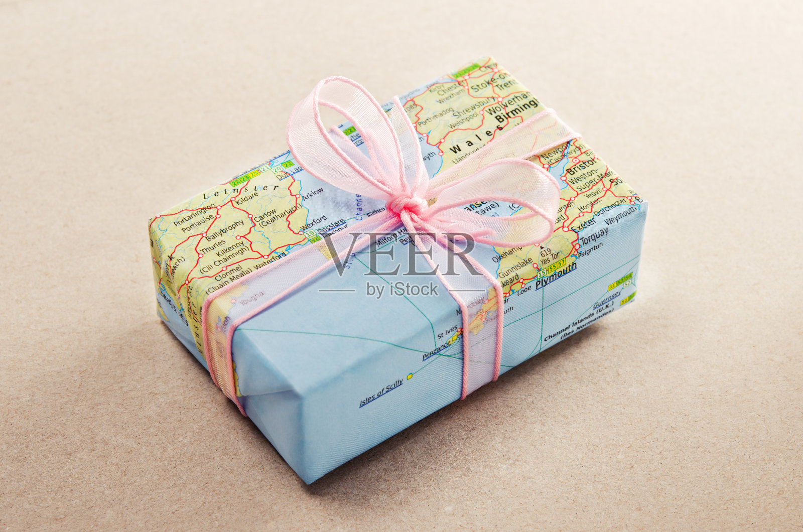 一份用地图纸和粉色蝴蝶结包装的一路平安礼物照片摄影图片