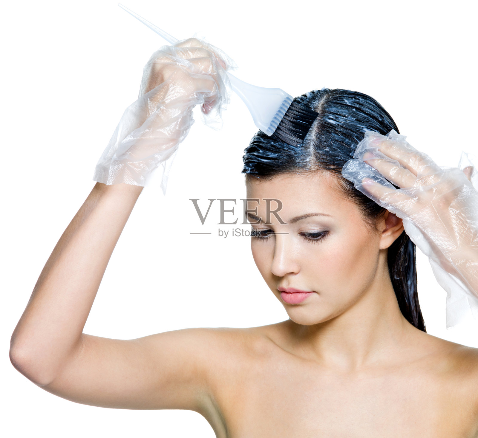 染发剂正在涂抹在一位年轻的黑发女子身上照片摄影图片