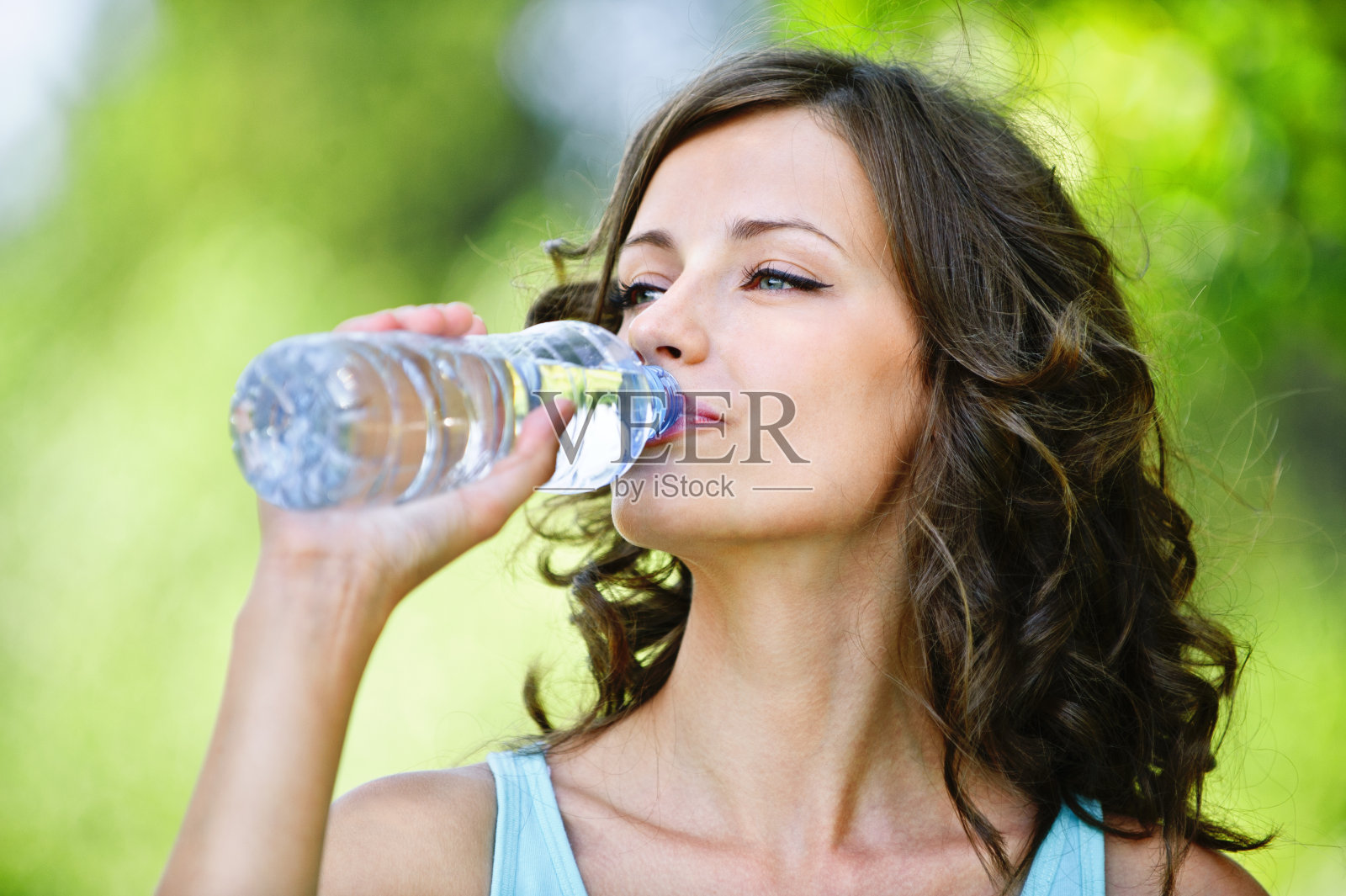 年轻的黑发女人在喝水照片摄影图片