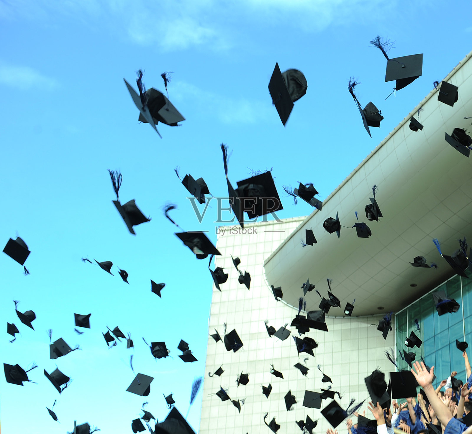 毕业帽在空中飞舞照片摄影图片