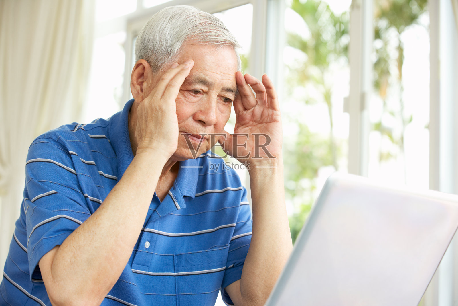 一位中国老人坐在书桌前使用笔记本电脑照片摄影图片