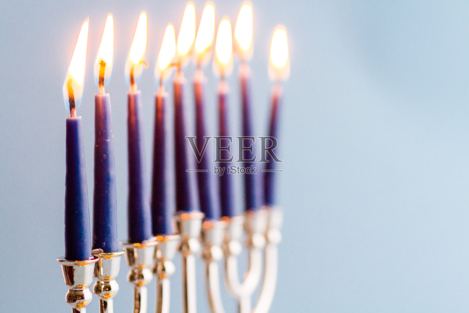 光明节的烛台，蓝色背景上有燃烧的蜡烛照片摄影图片