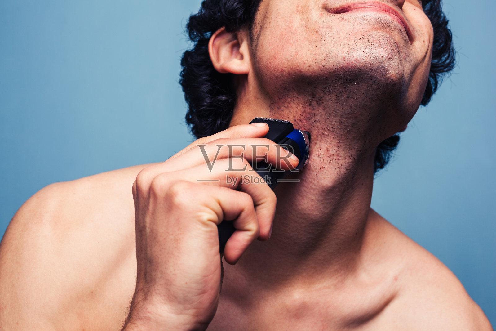 男人用电动剃须刀刮胡子照片摄影图片